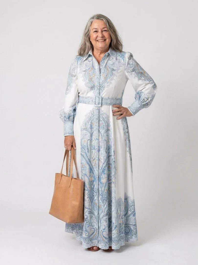 Side angle of belted waist and flowing maxi-length skirt on high neck printed dress