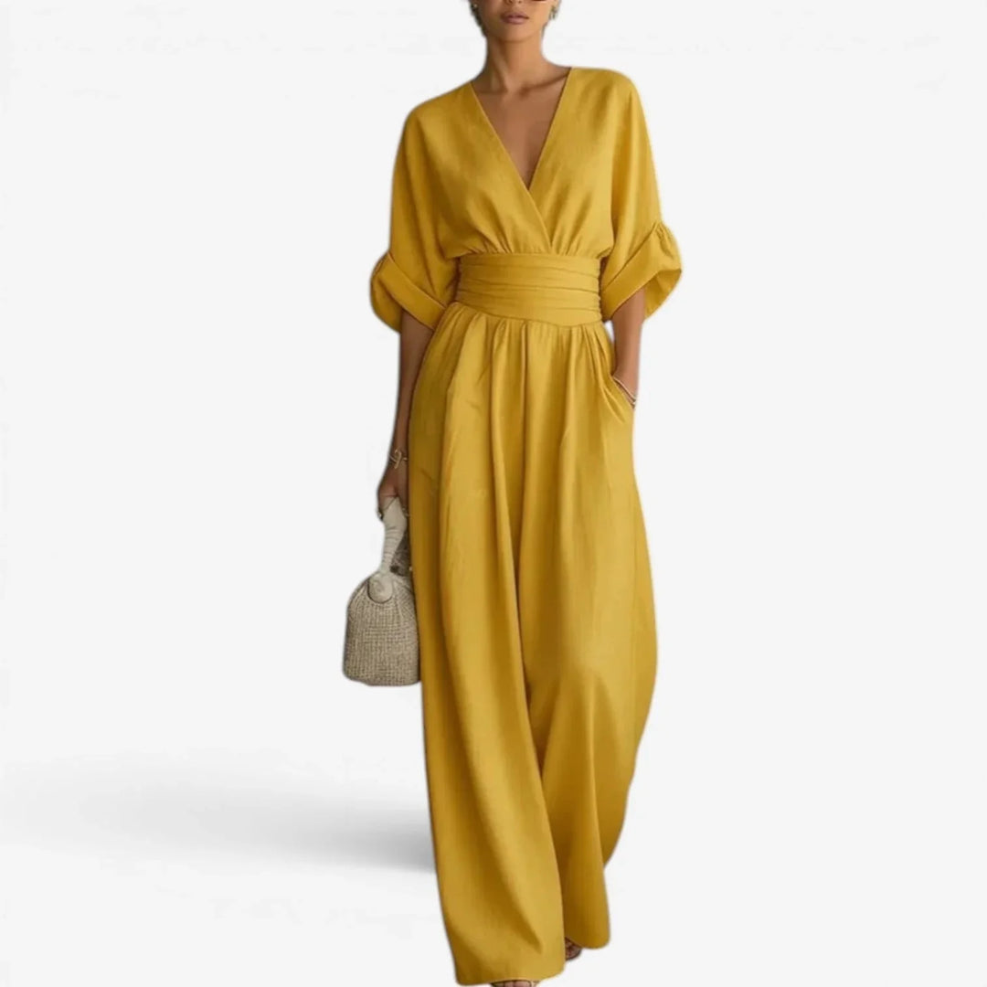 Side view showing gathered waistband and relaxed fit of wide sleeve jumpsuit