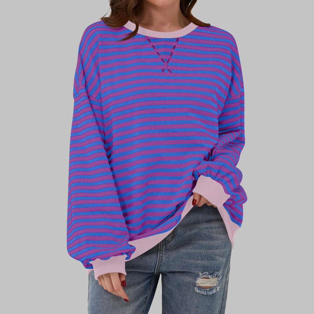 Full-length view of model wearing oversized striped sweatshirt in green and navy colourway
