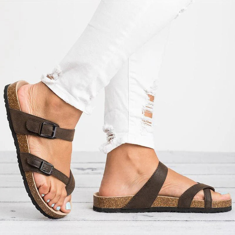 Side angle of women's flat cork sandals with toe-post design and wide instep strap