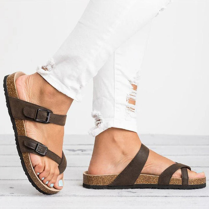 Side angle of women's flat cork sandals with toe-post design and wide instep strap