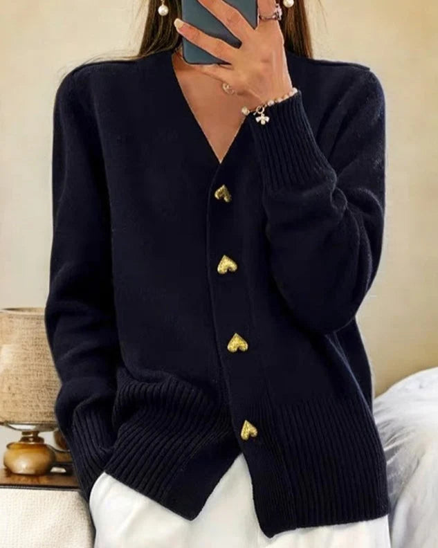 Detail of ribbed cuffs and hem on women's knit cardigan with heart buttons