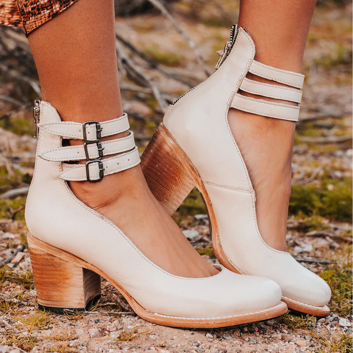 Close-up of buckle hardware on strappy ankle strap heels with smooth structured upper