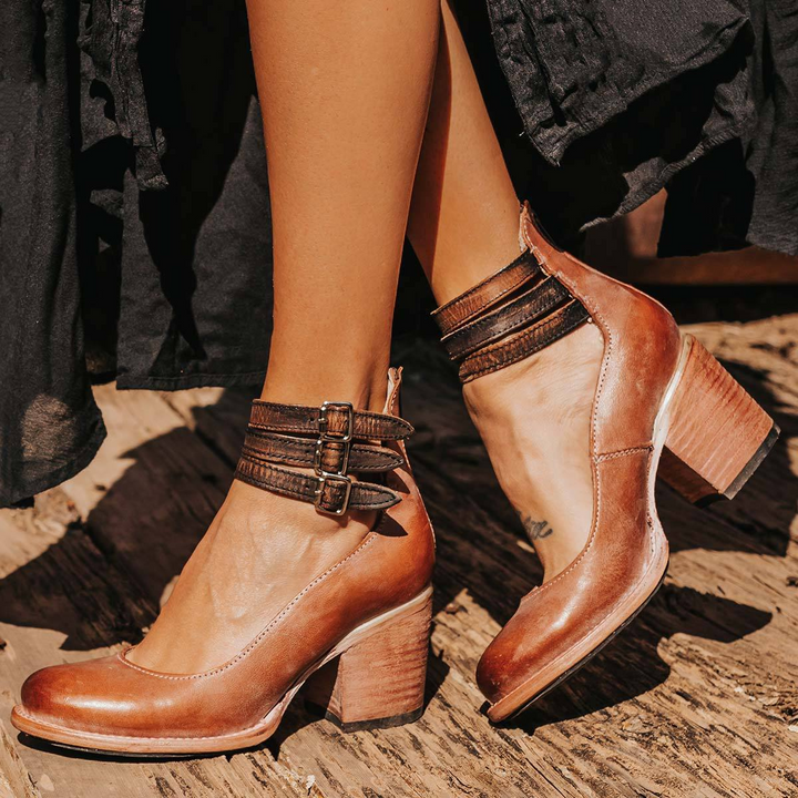 Woman styling strappy ankle strap heels with tailored black trousers for a polished daytime look