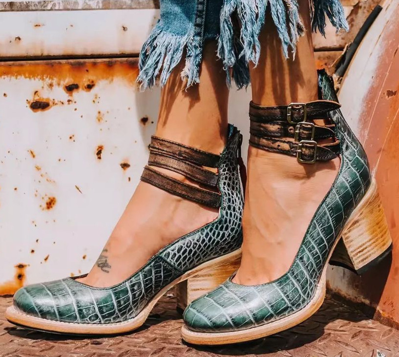 Detail shot of stacked wood-effect block heel on vintage-inspired strappy ankle strap boots