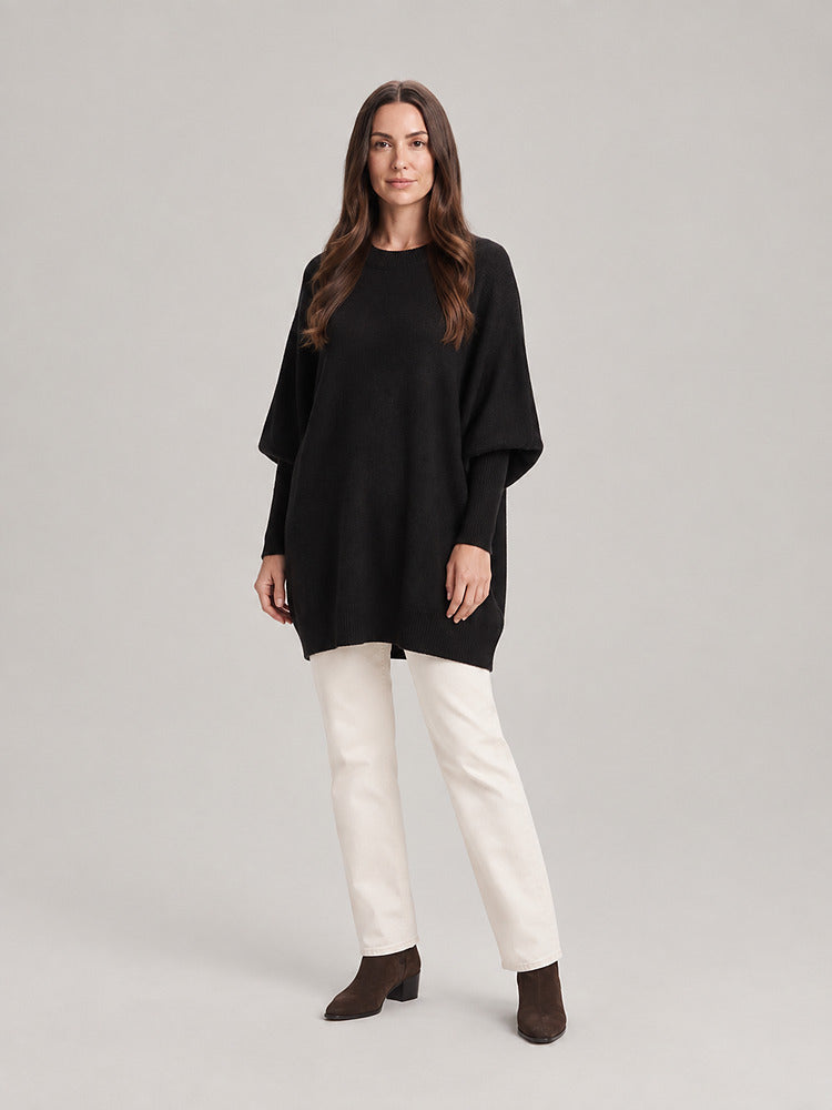 Women's chunky knit poncho jumper with an asymmetric hem in black