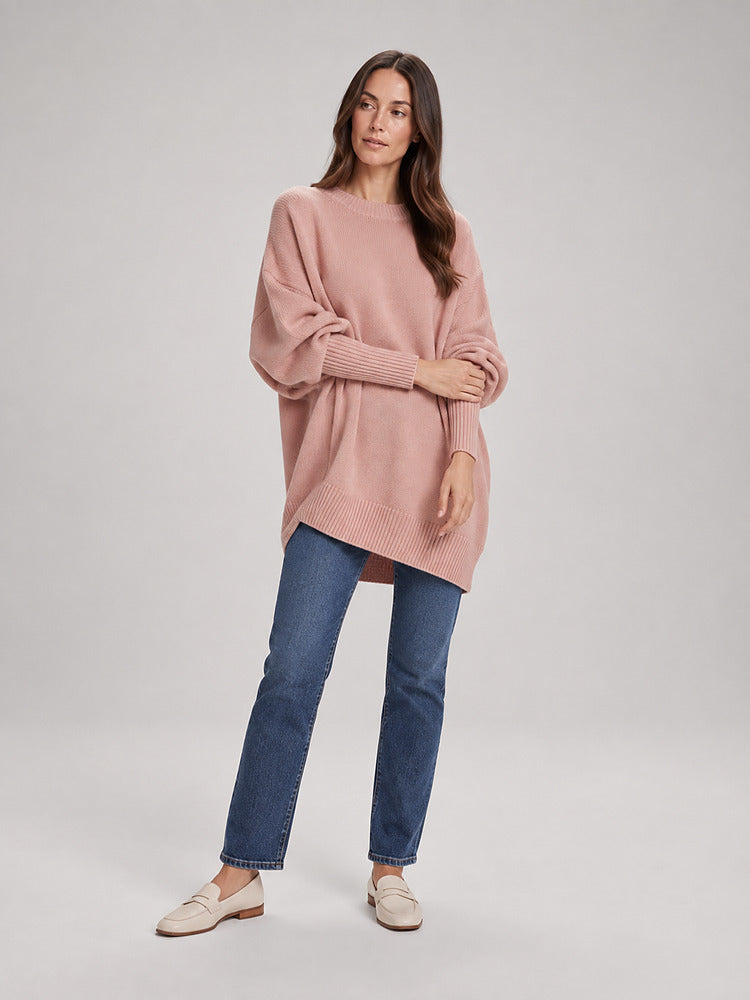 Women's chunky knit poncho jumper with an asymmetric hem in pink