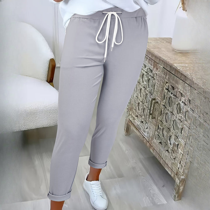Women's drawstring tapered trousers in light grey, worn on model